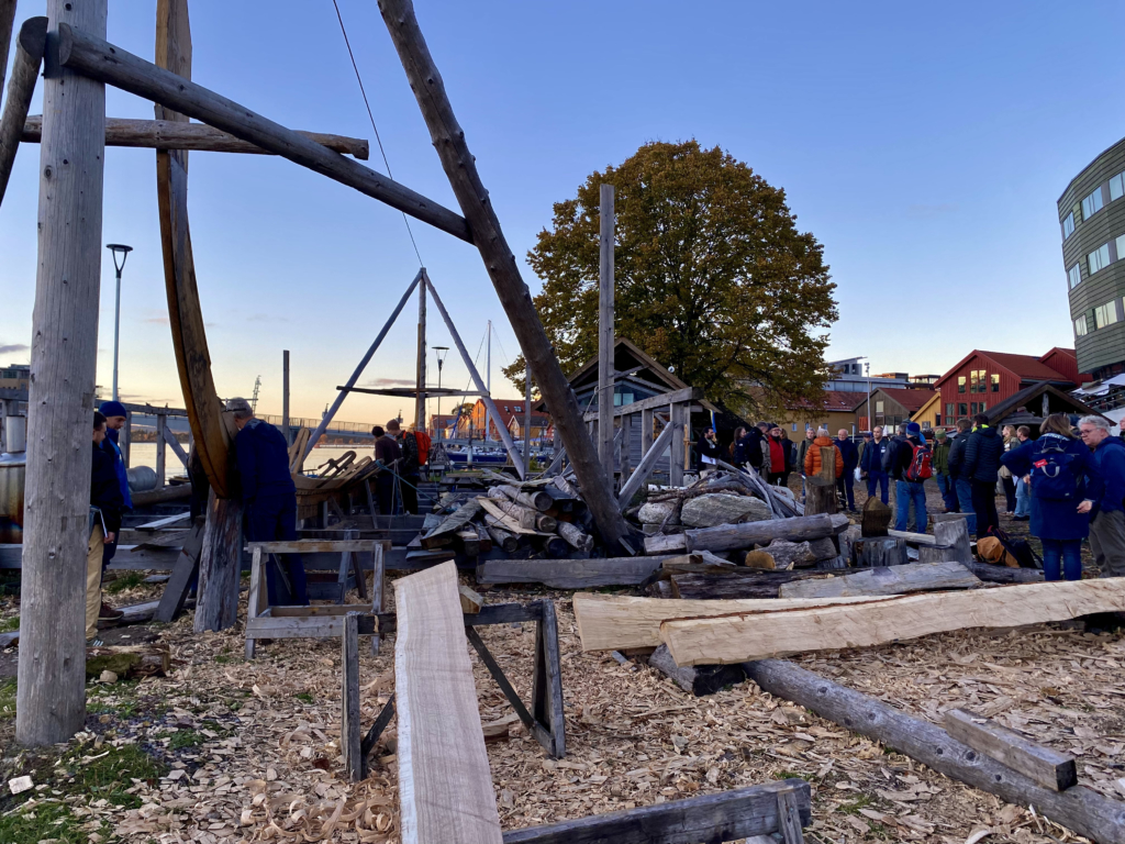 Deltakerne på omvisning hos Oseberg Vikingarv. Her ses også den påbegynte byggingen av en kopi av Gokstadskipet.