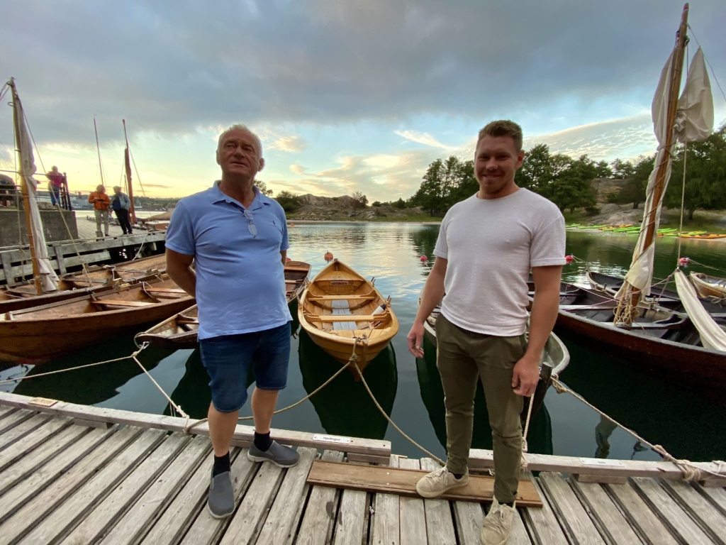 Lokale filmstjerner! Båtbygger Svein Walvick og lærling Jonathan Grimstad foran "Høvdingen" - sørlandssjekten de har bygget sammen. Foto: Forbundet KYSTEN